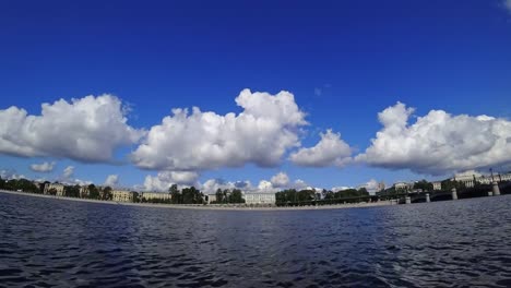 Time-lapse-of-rolling-cumulus-clouds-on-a-sunny-day.-Embankment-of-a-Neva-river-in-St.-Petersburg,-Russia.