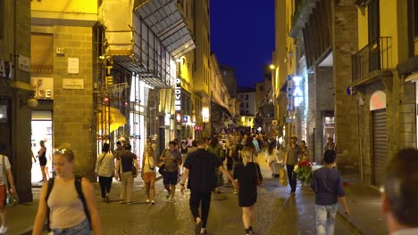 Florenz,-Toskana,-Italien.-Menschen-Fuß-entlang-der-beleuchteten-Via-Via-Por-Santa-Maria-in-der-Nacht