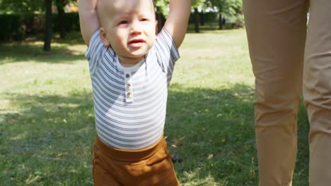 Bebé-niño-aprendiendo-a-caminar-al-aire-libre