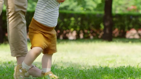 Mother-Supporting-Baby-Taking-First-Steps