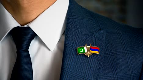 Geschäftsmann-zu-Fuß-in-Richtung-Kamera-mit-Freund-Land-Flaggen-Pin-Pakistan---Armenien