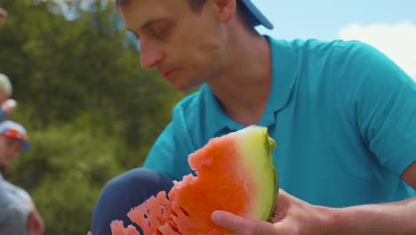 Man-eating-fresh-sweet-watermelon-outdoors,-close-up-crace-shot