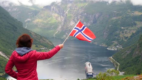 Touristen-mit-norwegischer-Flagge-und-Kreuzfahrtschiff-am-fjord