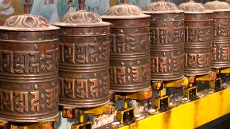 Spinning-Tibetan-Buddhist-prayer-wheels-at-Boudhanath-stupa,-Nepal