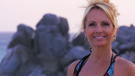 Close-up-portait-of-a-beautiful-older-woman-standing-on-the-beach