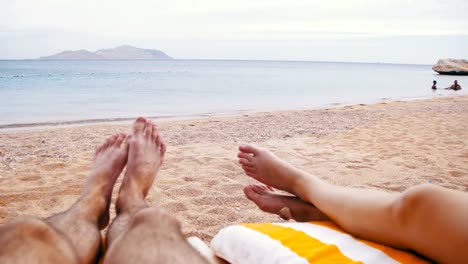 Beine-von-Menschen-am-Strand-Sonnenliege-liegen-in-der-Nähe-von-Meer