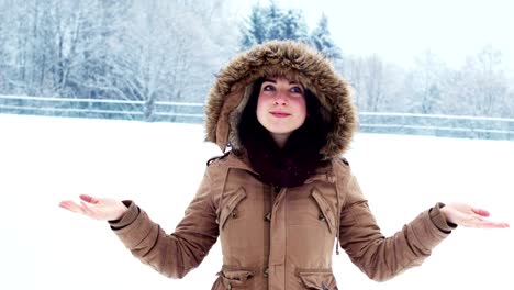Smiling-woman-in-fur-jacket-enjoying-the-snowfall