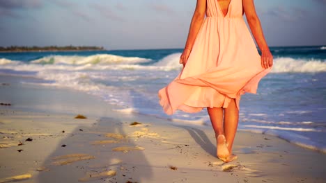 Beautiful-woman-on-summer-holidays-on-white-beach.-Close-up-female-legs.-SLOW-MOTION