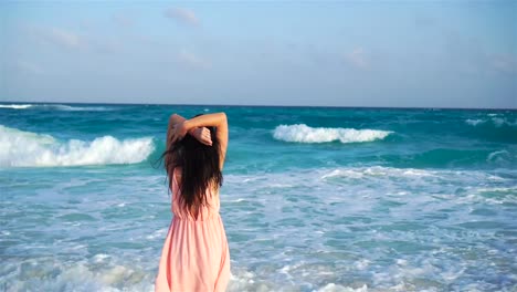 Joven-hermosa-mujer-en-vestido-en-la-orilla-del-mar-en-el-atardecer