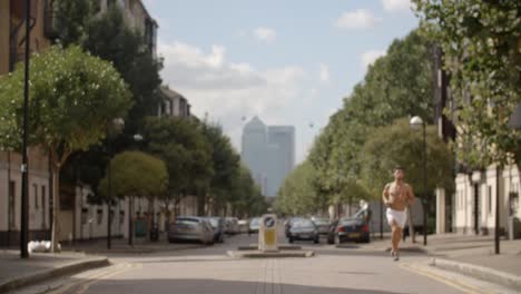 Un-joven-corriendo-aunque-Londres-con-ciudad-de-Londres-detrás-de-él.