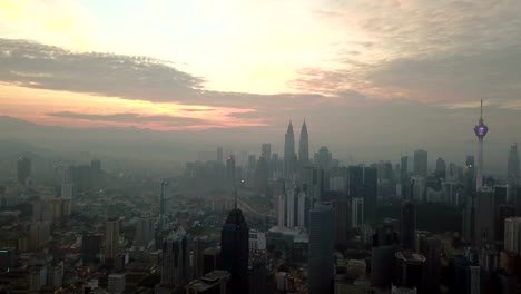 Cielo-ardiente-contra-rascacielos-de-Kuala-Lumpur-con-niebla-y-niebla-por-la-mañana.