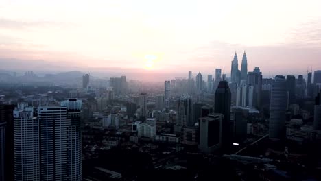 Cielo-ardiente-contra-rascacielos-de-Kuala-Lumpur-con-niebla-y-niebla-por-la-mañana.