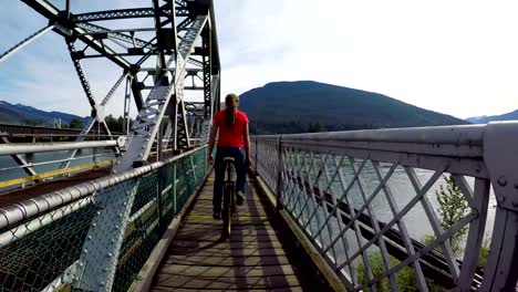 Woman-riding-unicycle-on-the-bridge-4k