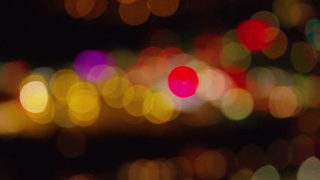 Aerial-shot-goes-out-of-focus-to-make-blurred-lights-at-night