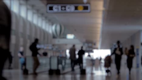 Blur-of-airport-hall-with-people-and-travelator