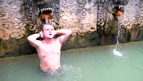 Ein-Mann-in-einem-Badeanzug-steht-unter-einen-Strom-von-Wasser-in-einem-Pool-mit-Wasserstoff-sulfide-Wasser