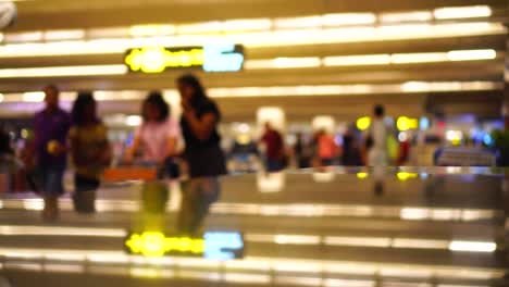 Travelers-passengers-in-airport-transit-terminal-walking-with-luggage-baggage-going-traveling.-Business-travel-people-out-of-focus-and-blurry-in-background-:-4k