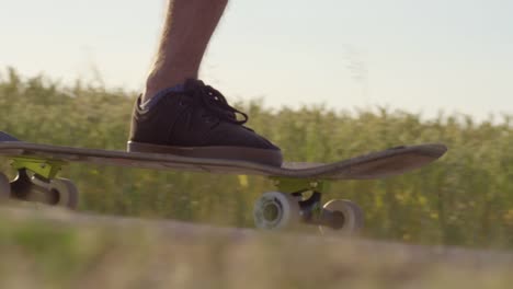 Skateboarder-drängen-neben-Weizenfeld-mit-epischen-Sonnenuntergang-und-Sonne-Fackeln---Schuss-auf-rot