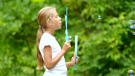 Little-girl-playing-with-soap-bubbles-outdoor.-Slow-motion.