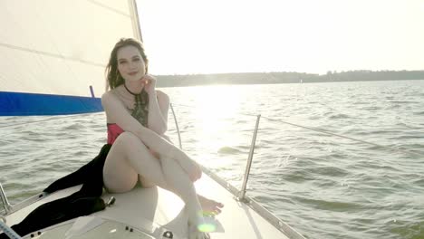 Beautiful-woman-wearing-elegant-summer-dress-and-sunglasses-and-posing-on-yacht.