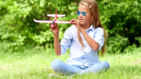 Neun-jährige-Mädchen-spielen-mit-Spielzeugflugzeug