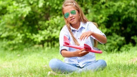 Neun-jährige-Mädchen-spielen-mit-Spielzeugflugzeug