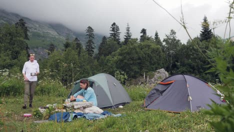 Friends-resting-in-summer-camping-while-tourist-hike-in-mountain