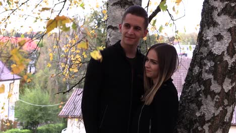 A-young-couple-sits-on-a-white-bedspread-in-autumn-park