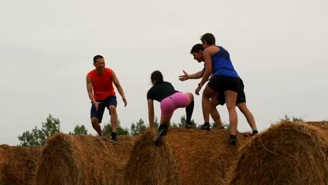 Joggers-helping-his-friend-while-jumping-from-hay-bales-4k