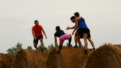 Jogger-hilft-seinem-Freund-beim-Springen-vom-Heu-Ballen-4k