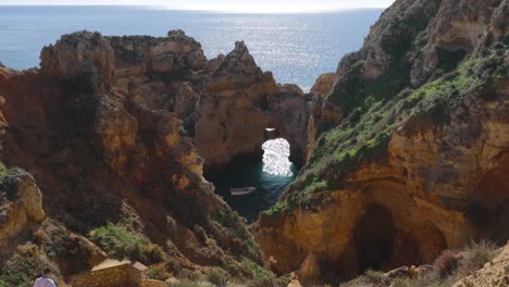 Ponta-da-Piedade,-berühmter-Ort-im-Süden-Portugals,-Lagos-Stadt,-Die-felsige-Küste,-die-Wellen-des-Atlantischen-Ozeans,-scharfe-Felsen,-azurblaues-Wasser,-gelbe-Blumen,-Bogen,-niemand,-wilder-Strand