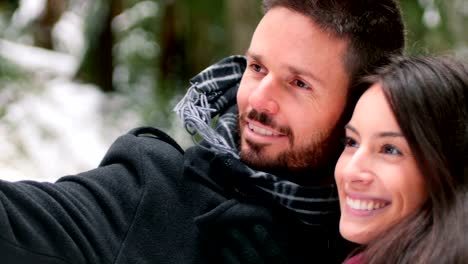 Couple-talking-a-selfie-with-mobile-phone-on-a-winter-day