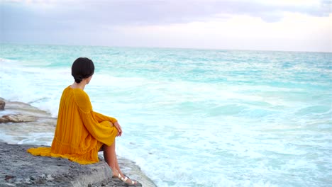 Junge-schöne-Frau-im-Sonnenuntergang-am-Meer.-Glückliches-Mädchen-in-Tracht-am-Abend-am-Strand