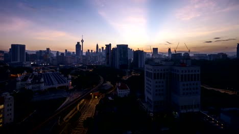 dramatic-sunrise-at-Kuala-Lumpur-city-with-sun-burst-ray.-Moving-and-changing-color-clouds.