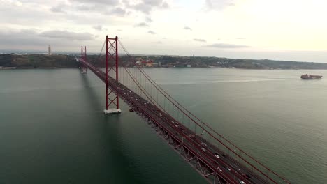 Bridge-Ponte-25-de-Abril-over-the-Tagus-river-in-Lisbon,-Portugal-at-evening-aerial-view