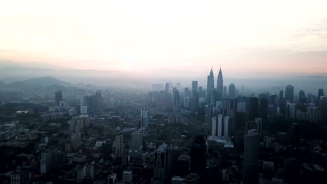 Cielo-ardiente-contra-rascacielos-de-Kuala-Lumpur-con-niebla-y-niebla-por-la-mañana.