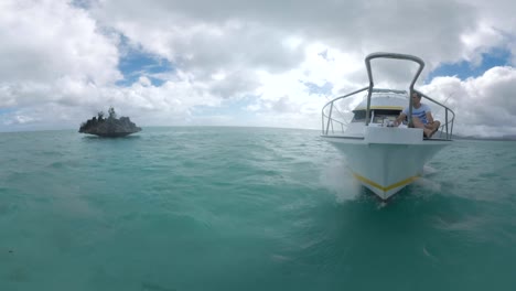 Man-tourist-relaxing-on-front-deck-of-the-yacht-sailing-in-ocean