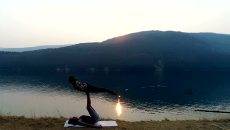 Mujeres-practicando-acroyoga-cerca-lago-4k