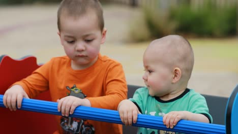 Dos-niños-felices-jugando-en-un-sube-y-baja