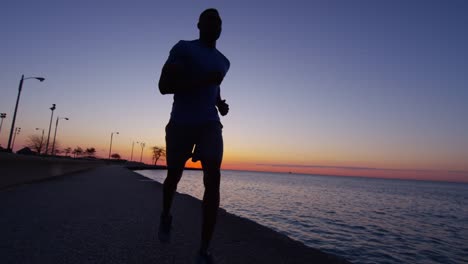 Ethnische-afroamerikanische-männliche-Silhouette-laufen-bei-Sonnenaufgang