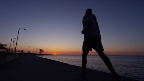 Ethnische-männliche-Silhouette-laufen-bei-Sonnenaufgang-für-fitness