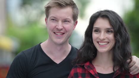 Young-happy-couple-thinking-together-outdoors