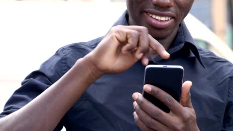 lächelnde-Schwarzafrikaner-mit-Smartphone-in-der-Stadt---Zeitlupe
