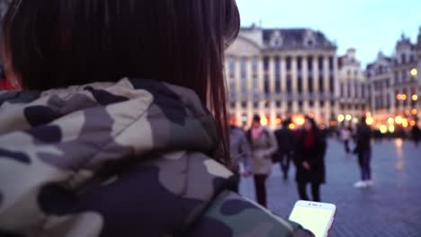 Tourist-girl-walks-and-looks-at-attractions-on-Grand-Place-in-Brussels,-Belgium