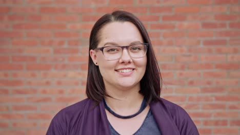 Young-Lady-Smiling-against-a-Brick-Wall-Background