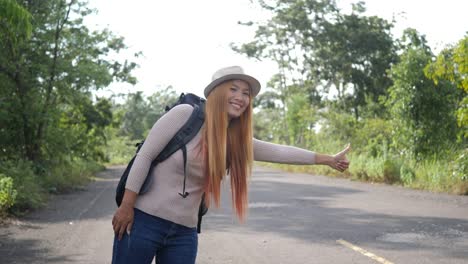 Traveler-woman-backpacker-hitchhiking-on-the-road-and-walking.