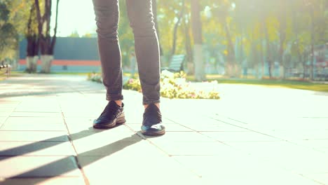 Close-up-of-the-legs-of-a-young-guy-who-is-waiting-for-someone-in-the-park