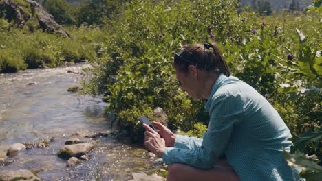 Touristischen-Frau-ruht-auf-Fluss-Ufer-und-Foto-mit-dem-Handy-zu-tun