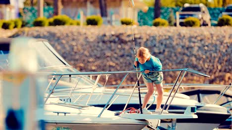 Little-girl-a-child-on-a-yacht-or-on-a-boat-holds-a-fishing-pole-and-looks-at-the-fish