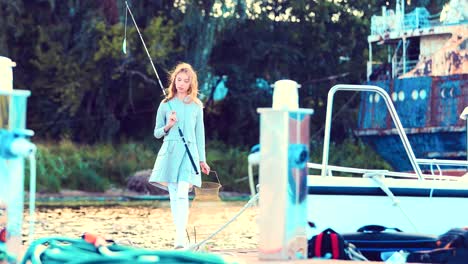 Girl-is-holding-a-fishing-rod-in-her-hands-and-posing-on-the-camera